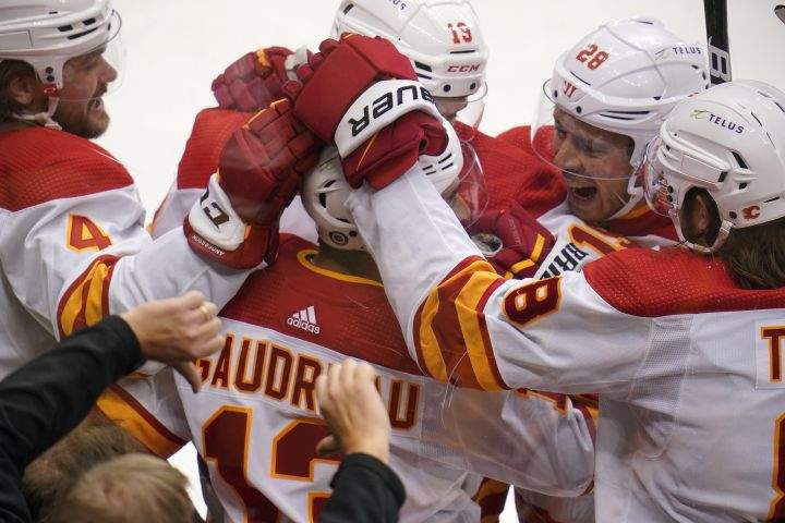Calgary Flames’ Johnny Gaudreau (13) celebrates with teammates after scoring during the first period of an NHL hockey game against the Pittsburgh Penguins in Pittsburgh, Thursday, Oct. 28, 2021.