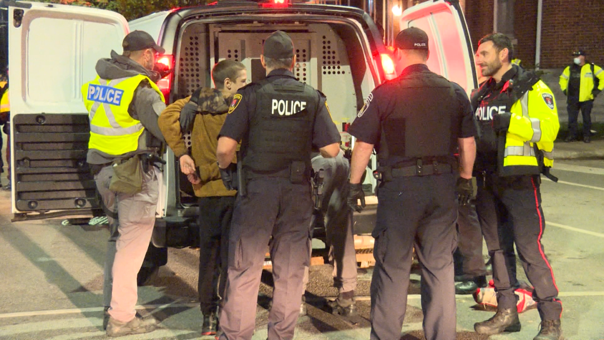 Police arrest a party-goer during homecoming celebrations in Kingston's University District.