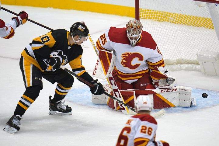 Calgary Flames goaltender Jacob Markstrom (25) blocks a shot by Pittsburgh Penguins’ Drew O’Connor (10) during the first period of an NHL hockey game in Pittsburgh, Thursday, Oct. 28, 2021.