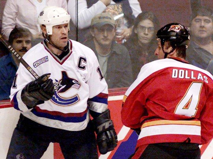 Vancouver Canucks Mark Messier left, gives Calgary Flames Bobby Dollas (4) his patented stare after they collided during the first period of NHL action in Vancouver Wednesday Feb. 9, 2000.