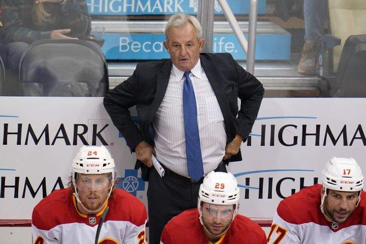 Calgary Flames coach Darryl Sutter stands behind the bench during the first period of the team’s NHL hockey game against the Pittsburgh Penguins in Pittsburgh, Thursday, Oct. 28, 2021.