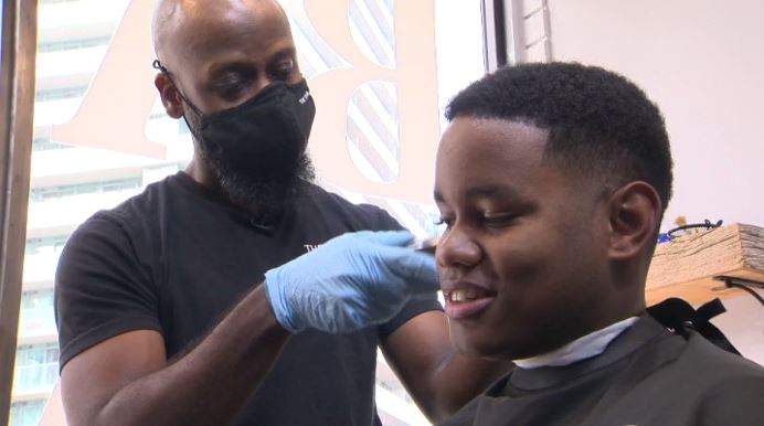 Patrice Alexander, owner of The Forum Barber Parlour, cuts hair of longtime client Jonathon Jaundoo.