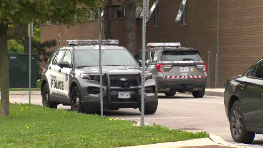 Police are seen at George S. Henry Academy on Tuesday.