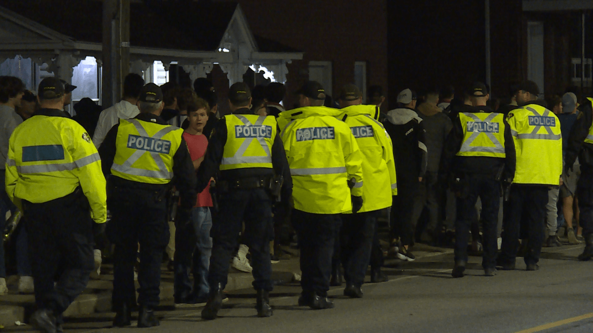 Police gather in Kingston's university district during homecoming parties.