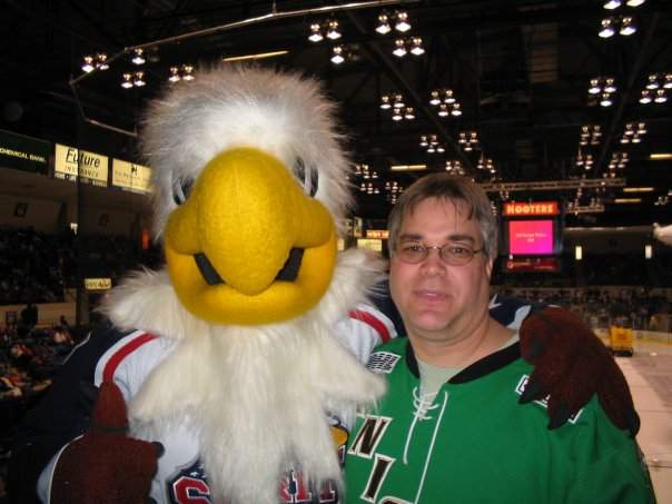 Longtime London Knights fan Rob Matic poses alongside Sammy Spirit during a game hosted by the Saginaw Spirit.