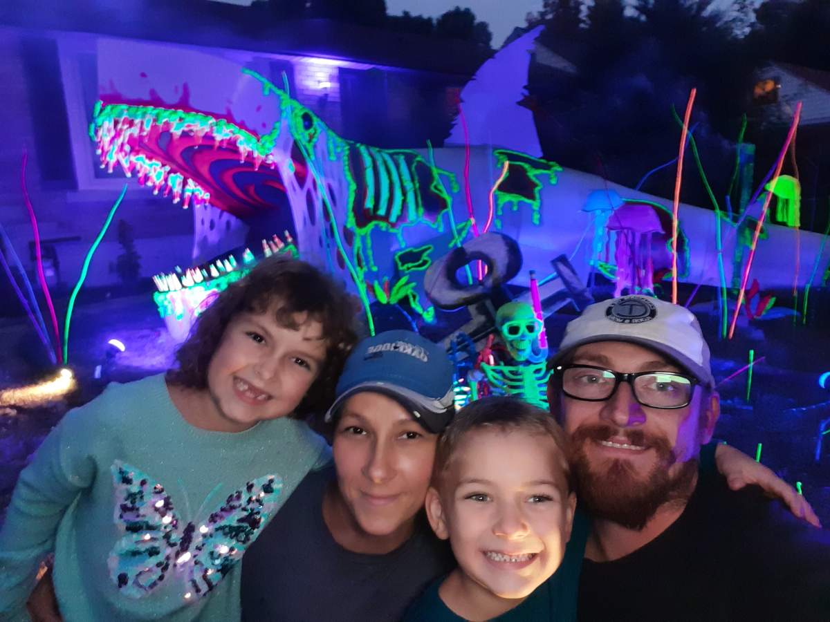 Sarah Appleby and her family pose in front of Bitey, a great white glow-in-the-dark shark that helped reel in more than 1,200 pounds of donations for the London Food Bank.