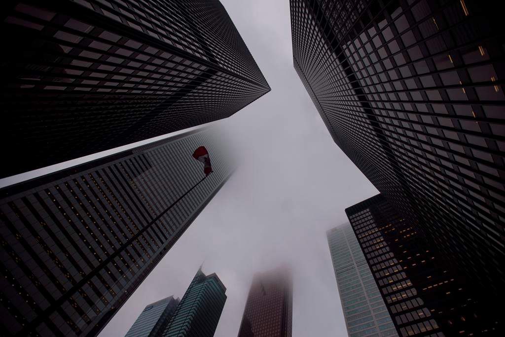 The Canadian flag blows in the wind in the heart of the financial district in Toronto on June 27, 2018. THE CANADIAN PRESS/Tijana Martin.