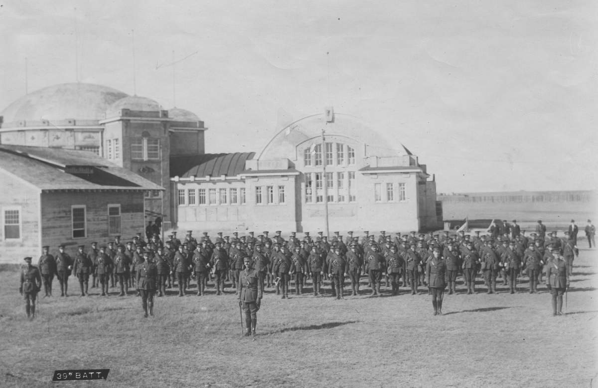 Photograph of members of the 39th Battery in front of the Lethbridge Exhibition Pavilion.