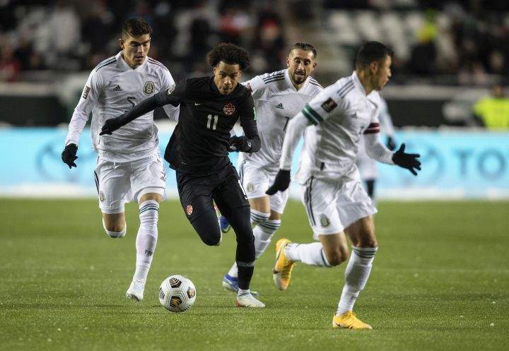 Canada’s Tajon Buchanan (11) is chased by Mexico players during World Cup Qualifiers in Edmonton, Tuesday, Nov. 16, 2021.
