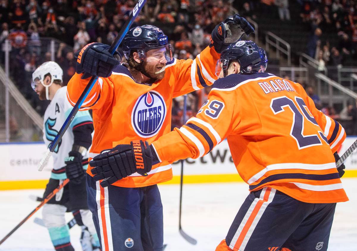 Seattle Kraken’s Adam Larsson (6) skates past as Edmonton Oilers’ Duncan Keith (2) and Leon Draisaitl (29) celebrate a goal during second period NHL action in Edmonton, Monday, Nov. 1, 2021.