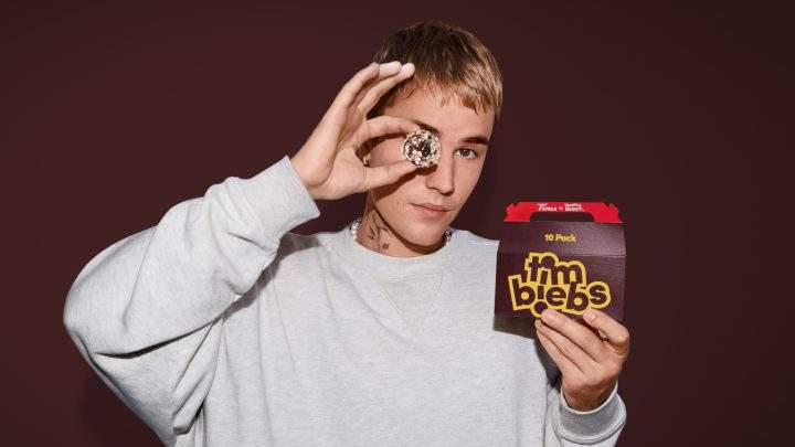 Justin Bieber holds a pack of Tim Hortons' new Timbit flavours, called Timbiebs in this undated handout photo. Tim Hortons has teamed up with pop superstar Justin Bieber to launch three new Timbit flavours —called Timbiebs — along with co-branded merchandise.