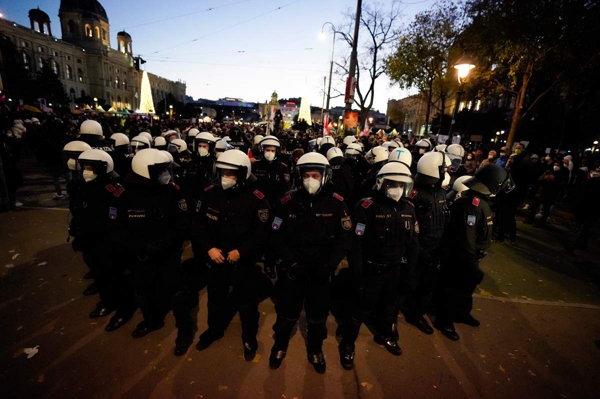 Police officers stand in a circle as they check the identity of demonstrators during a demonstration against measures to battle the coronavirus pandemic in Vienna, Austria, Saturday, Nov. 20, 2021. (AP Photo/Florian Schroetter)