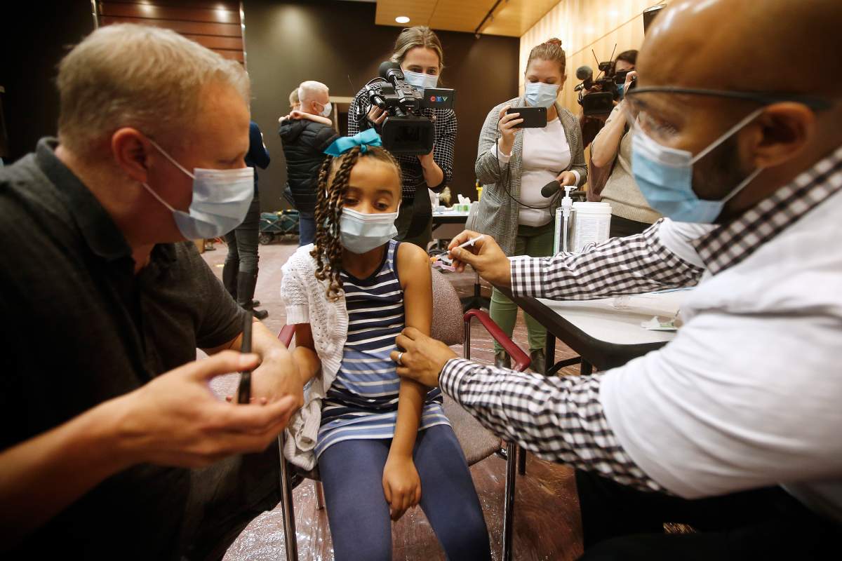 Nala Larson, 6, holds onto her father, Scott, as she receives her first inoculation in the COVID-19 vaccination clinic at the Convention Centre in Winnipeg, Thursday, November 25, 2021. Manitoba opened up COVID-19 vaccinations to children 5-11. 