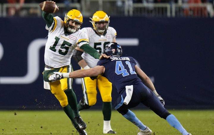 Edmonton Elks quarterback Taylor Cornelius (15) avoids a tackle by Toronto Argonauts linebacker Brady Sheldon (41) during second half CFL football action in Toronto, Tuesday, Nov. 16, 2021. 
