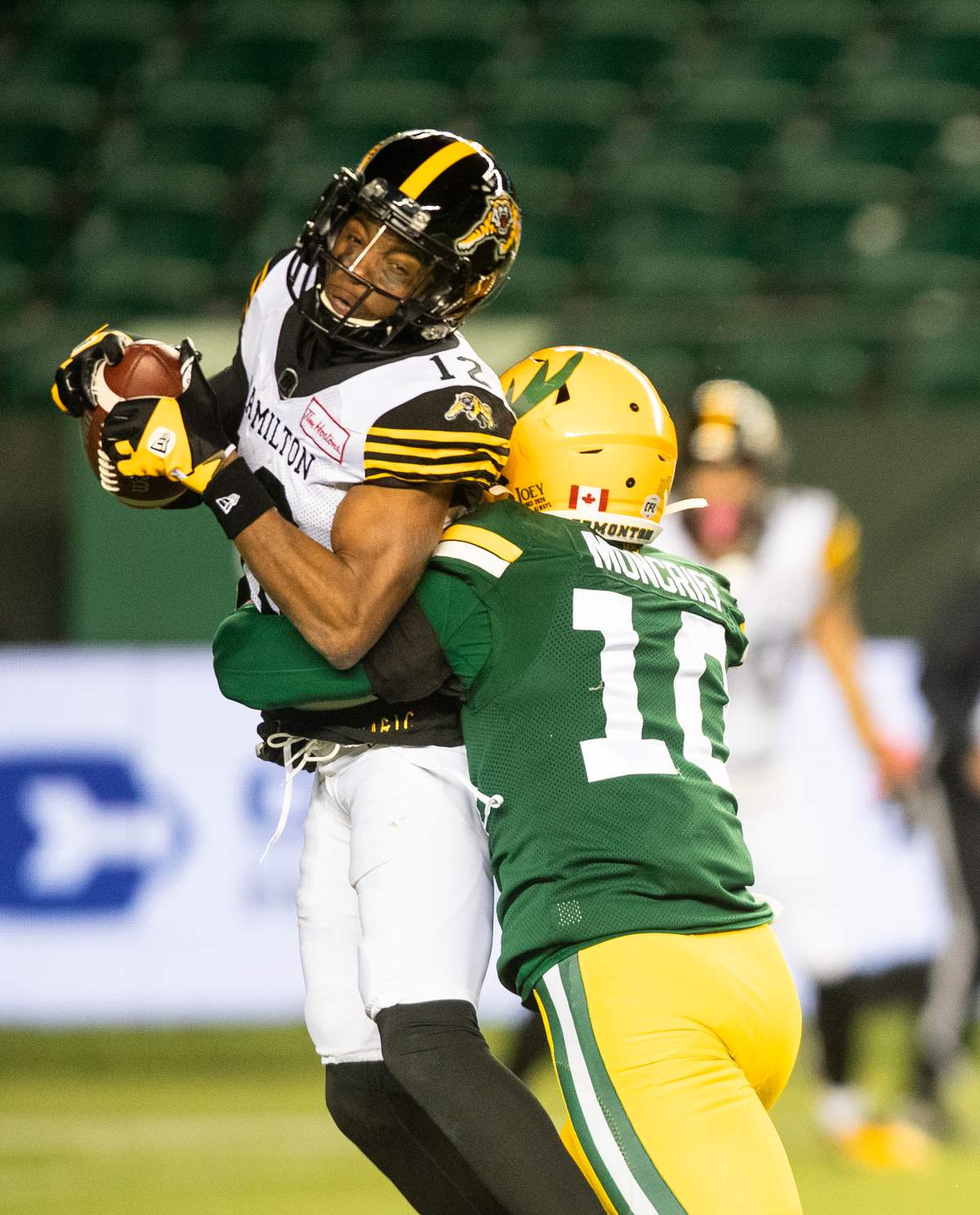 Hamilton Tiger-Cats’ Tim White (12) makes the catch as Edmonton Elks’ Derrick Moncrief (10) tackles him during first half CFL action in Edmonton, Alta., on Friday October 29, 2021.