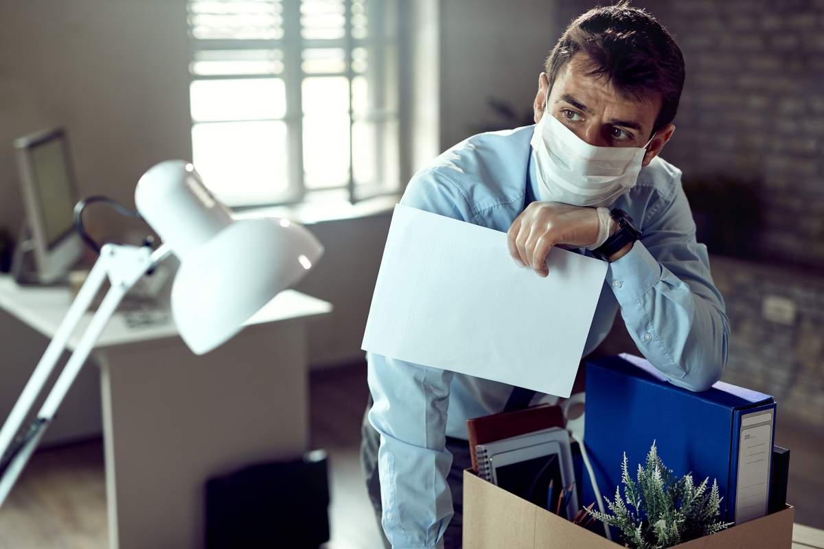 Young businessman packing his belongings and feeling worried after losing his job due to coronavirus pandemic.