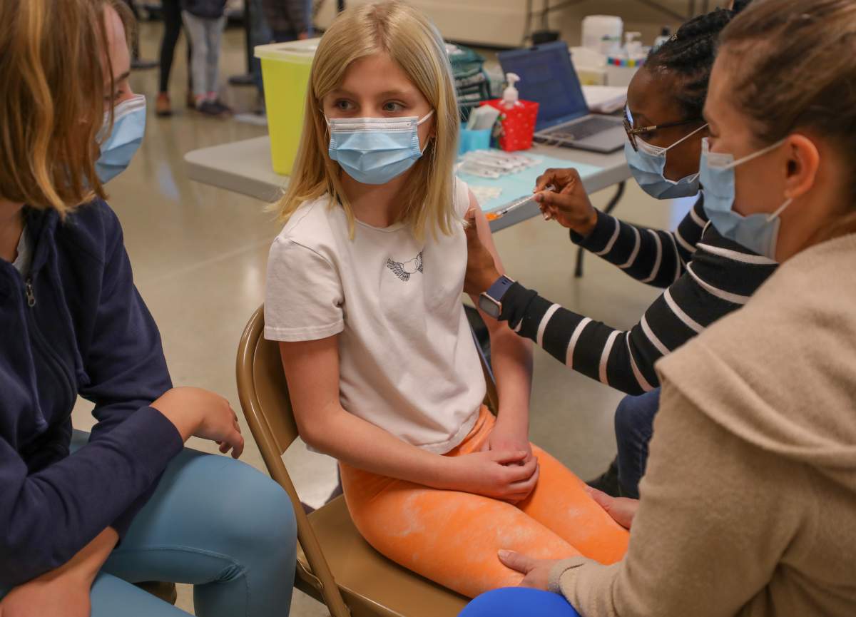 Launa Antolovichsits with her daughter Violet Antolovich, 9, as she receives a COVID-19 vaccine in Calgary, Alta., on November 26, 2021. Leah Hennel / AHS