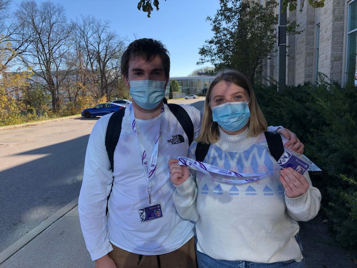 Andrew Sarazin (left) and Kaitlyn Patterson pose with their new lanyards and card holders just moments after picking them up on Monday.