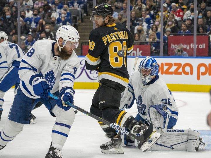 Toronto Maple Leafs defenceman Jake Muzzin (8) battles to clear the puck as Boston Bruins right wing David Pastrnak (88) and Maple Leafs goaltender Jack Campbell (36) look on during first period NHL action in Toronto on Saturday, November 6, 2021.