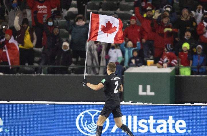 Canada’s Alistair Johnston (2) parades the flag to celebrate the win over Mexico during World Cup Qualifiers in Edmonton, Tuesday, Nov. 16, 2021.
