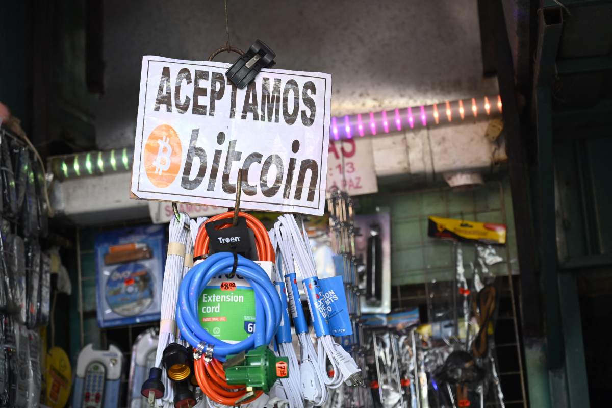 A signal that reads “We accept bitcoin here” is seen outside a street stall in Sal Salvador, on November 18, 2021.