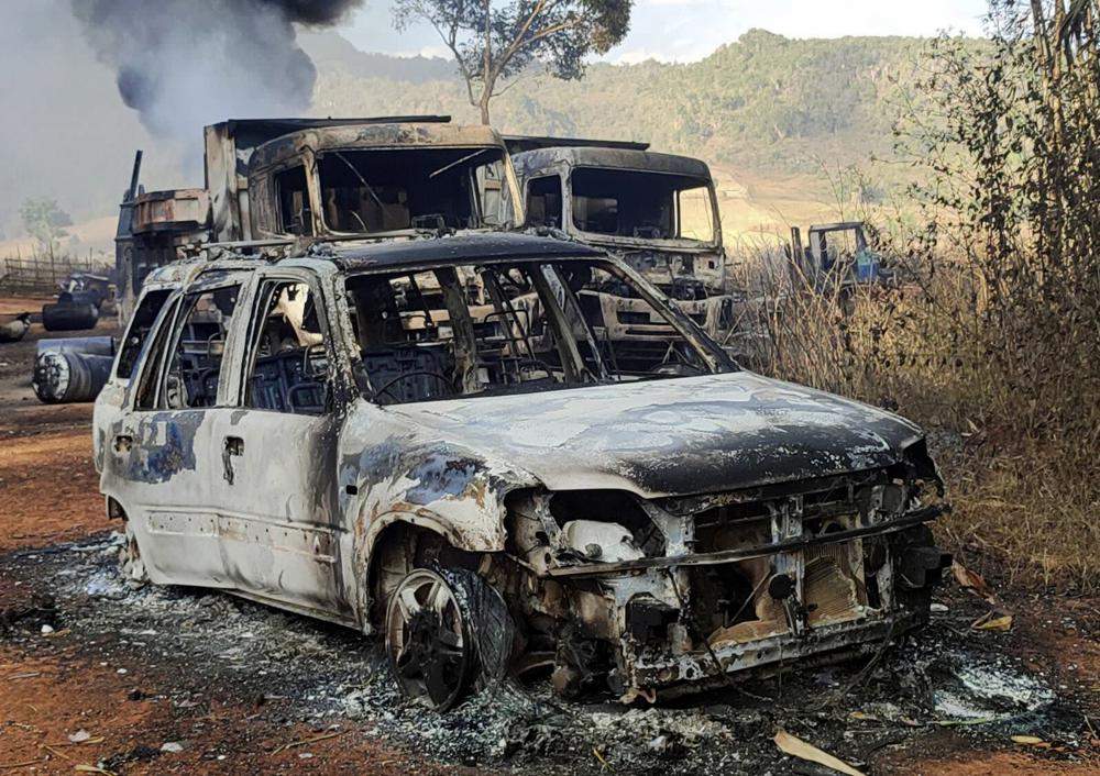 In this photo provided by the Karenni Nationalities Defense Force (KNDF), vehicles smolder in Hpruso township, Kayah state, Myanmar, Friday, Dec. 24, 2021. Myanmar government troops rounded up villagers, some believed to be women and children, fatally shot more than 30 and set the bodies on fire, a witness and other reports said Saturday. (KNDF via AP).