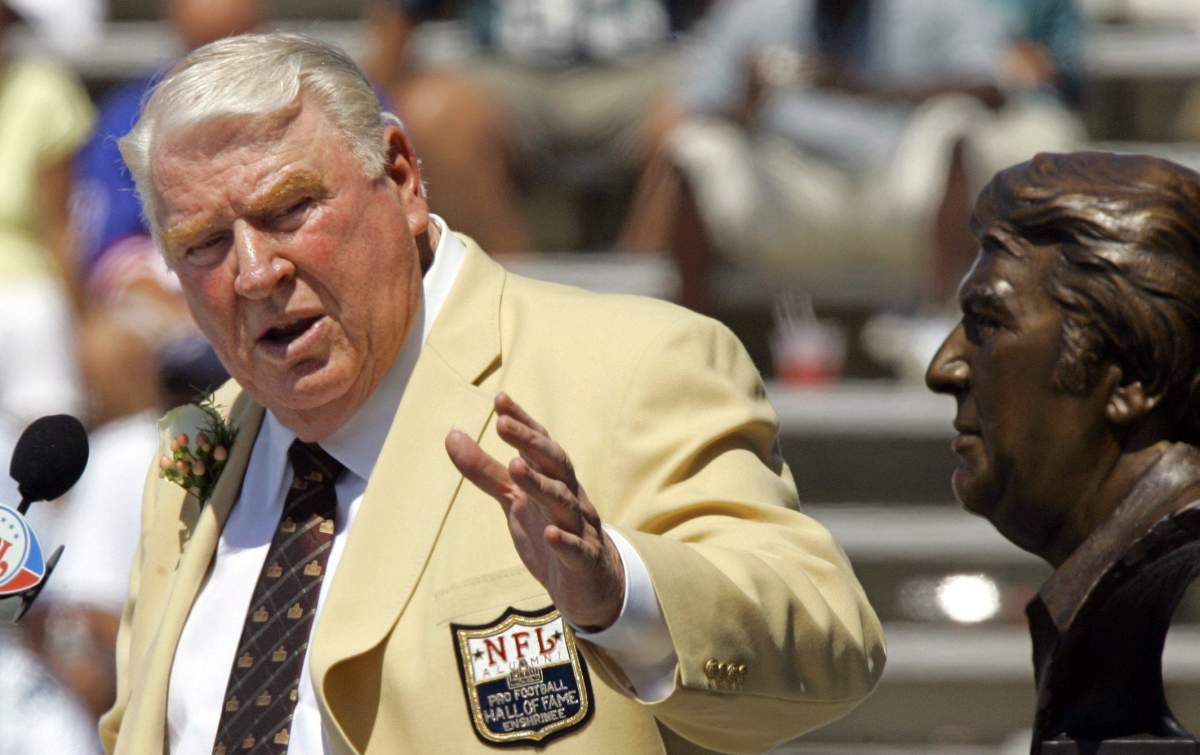 FILE – In this Aug. 5, 2006, file photo, former Oakland Raiders coach John Madden gestures toward a bust of himself during his enshrinement into the Pro Football Hall of Fame in Canton, Ohio. (AP Photo/Mark Duncan, File)