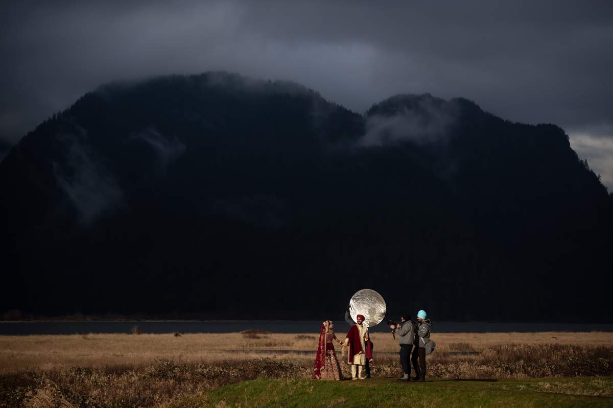 Newlyweds Deep Punia, left, and Parminder Punia pose for wedding photos at Pitt-Addington Marsh nature preserve, in Pitt Meadows, B.C., on Saturday, February 6, 2021.