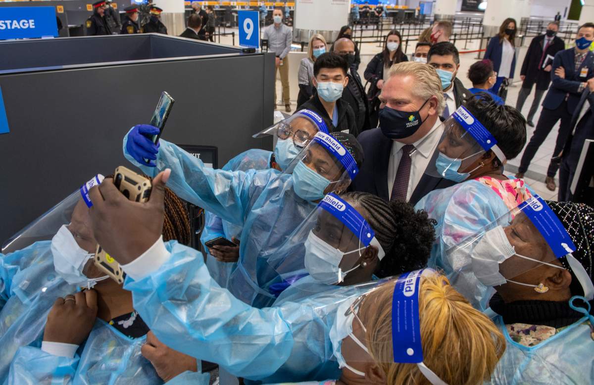 Ontario Premier Doug Ford is surrounded by selfie seeking nurses at the COVI-19 testing centre in Terminal 3 at Pearson Airport in Toronto on Wednesday, Feb. 3, 2021.