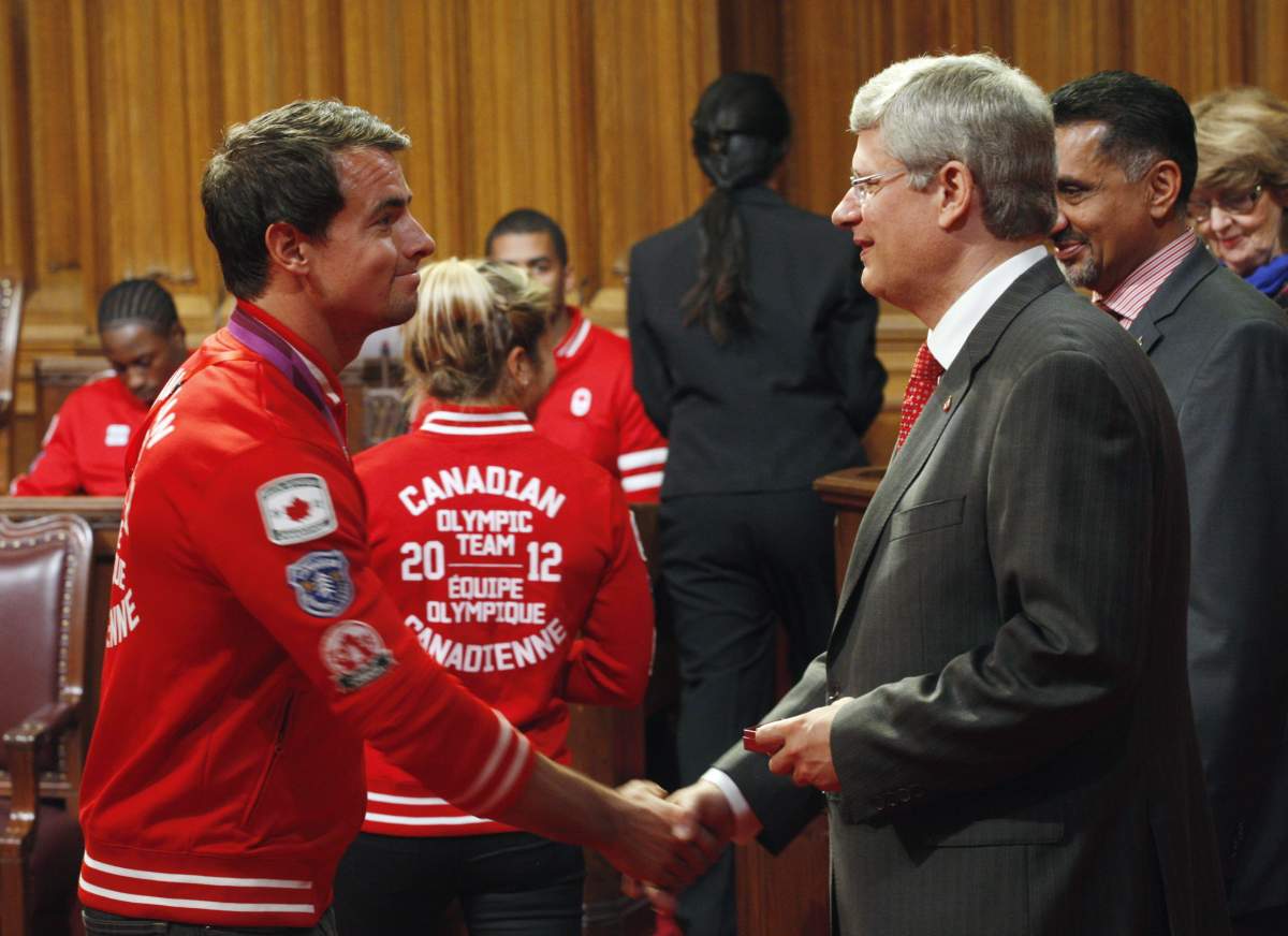 Prime Minister Stephen Harper presents Olympic kayaker Adam van Koeverden with the Diamond Jubilee medal during a ceremony in the Senate on Parliament Hill in Ottawa, Sept. 19, 2012.