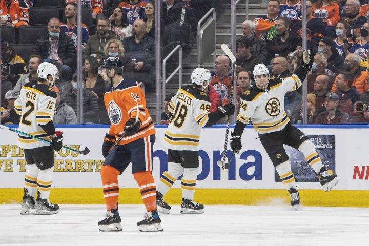 Boston Bruins’ Craig Smith (12), Matt Grzelcyk (48) and Jake DeBrusk (74) celebrate a goal as Edmonton Oilers’ Devin Shore (14) skates off during second period NHL hockey action in Edmonton, Alta., on Thursday December 9, 2021.