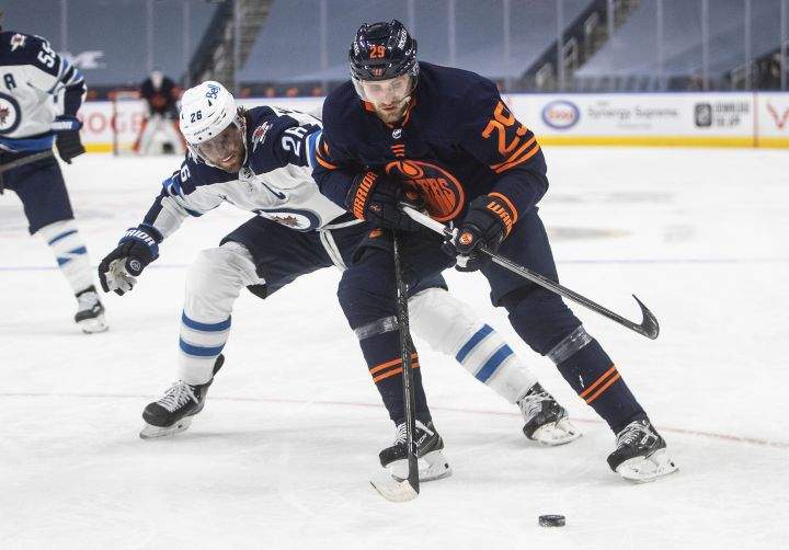 Edmonton Oilers’ Leon Draisaitl (29) battles for the puck with Winnipeg Jets’ Blake Wheeler (26) during second period NHL Stanley Cup playoff action in Edmonton on Friday, May 21, 2021.