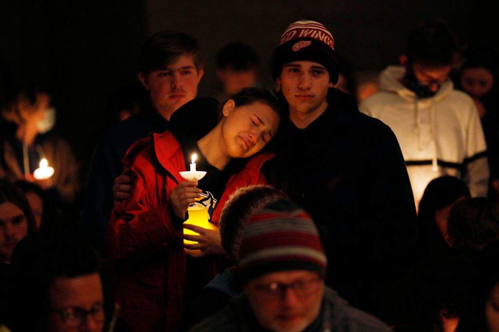 A person becomes emotional as Oxford High students holding candles are asked to stand during a vigil after a shooting at Oxford High School at Lake Pointe Community Church in Lake Orion, Mich., on Nov. 30, 2021.