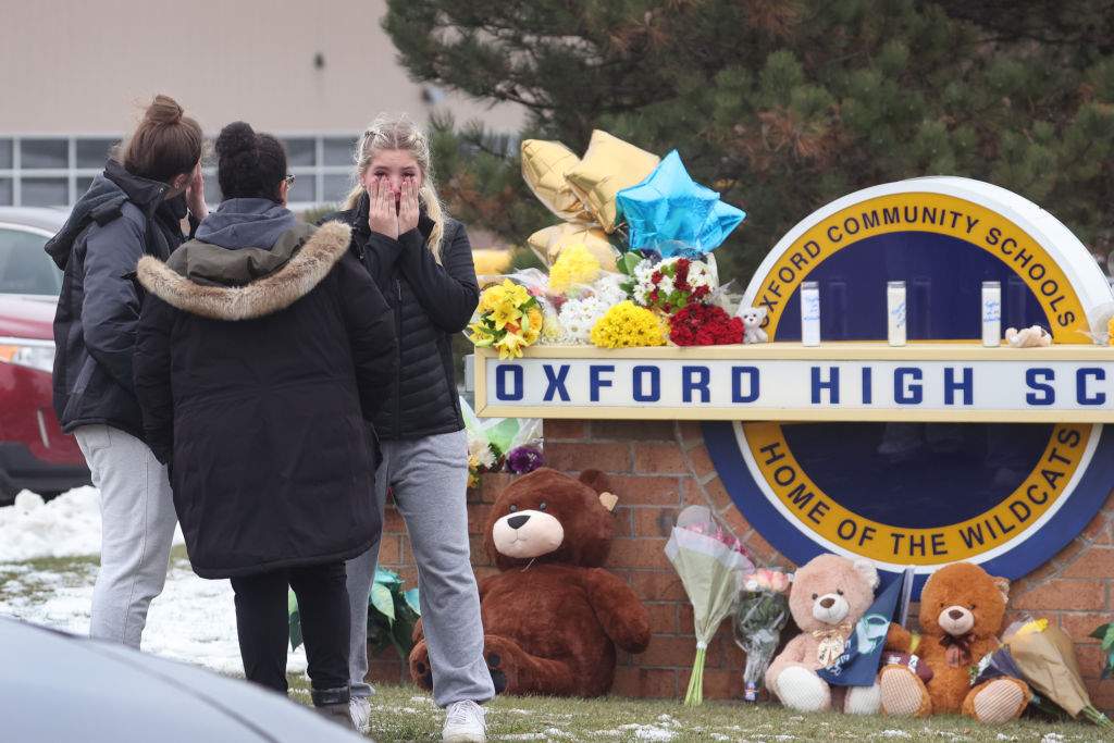 Mourners react as they visit a makeshift memorial outside of Oxford High School on December 01, 2021 in Oxford, Michigan.