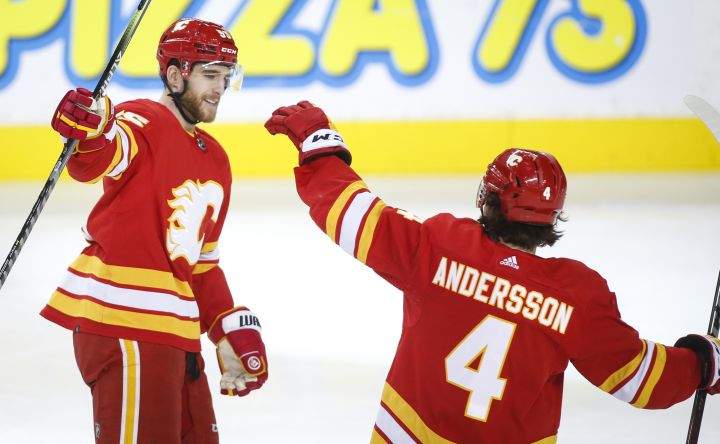 Calgary Flames’ Noah Hanifin, left, celebrates his goal with teammate Rasmus Andersson during second period NHL hockey action against the Calgary Flames in Calgary, Thursday, Dec. 9, 2021.