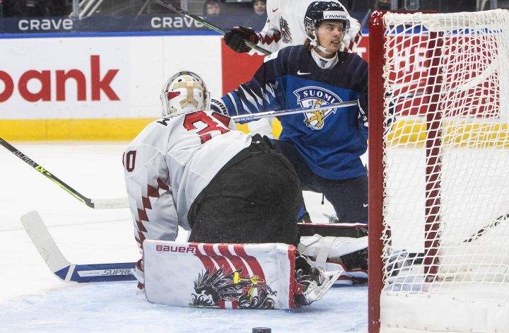 Finland’s Ville Koivunen (24) scores a goal on Austria’s goalie Sebastian Wraneschitz (30) during first period IIHF World Junior Hockey Championship action in Edmonton, Monday, Dec. 27, 2021.