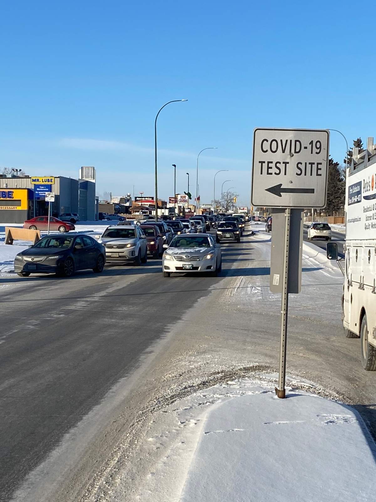 Cars line up at a drive-thru COVID-19 testing site on Regent Avenue Tuesday morning.