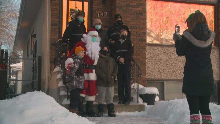Members of the Edmonton Police Service take a photo with Annabelle Jimmy-Delorme and her grandsons.