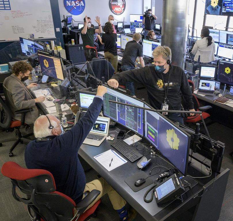 Engineering teams celebrate at the Space Telescope Science Institute in Baltimore as the second primary mirror wing of NASA's James Webb Space Telescope unfolds, before beginning the process of latching the mirror wing into place, Saturday, Jan. 8, 2022.