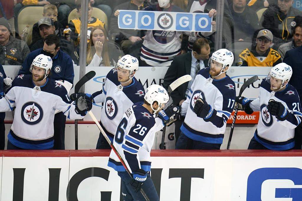 Winnipeg Jets’ Blake Wheeler (26) returns to his bench after scoring during the first period of an NHL hockey game against the Pittsburgh Penguins in Pittsburgh, Sunday, Jan. 23, 2022.