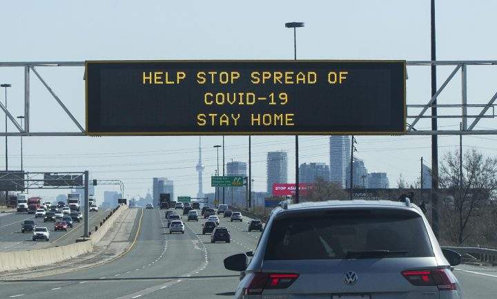 A screen with words of ”HELP STOP SPREAD OF COVID-19 STAY HOME” is seen in Toronto on April 8, 2021.