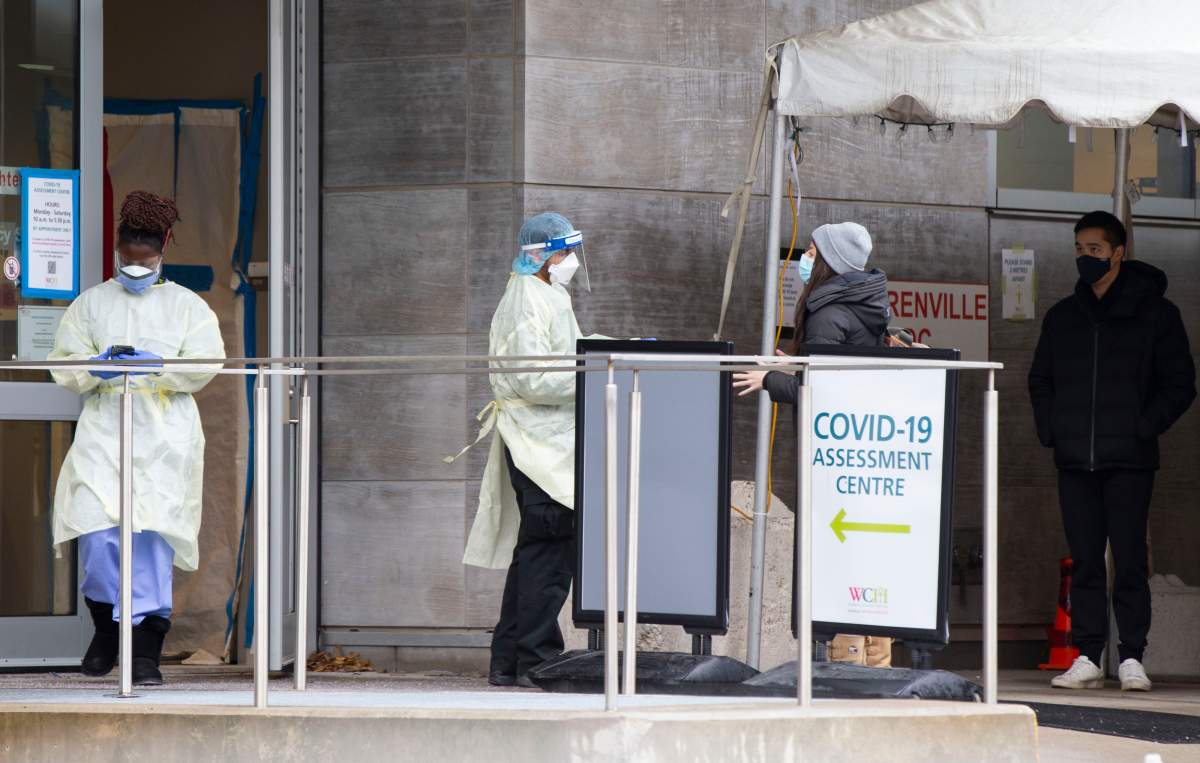 TORONTO, Dec. 24, 2021  A security officer wearing personal protective equipment talks with a woman at the entrance of a COVID-19 assessment center in Toronto, Ontario, Canada, on Dec. 24, 2021. 