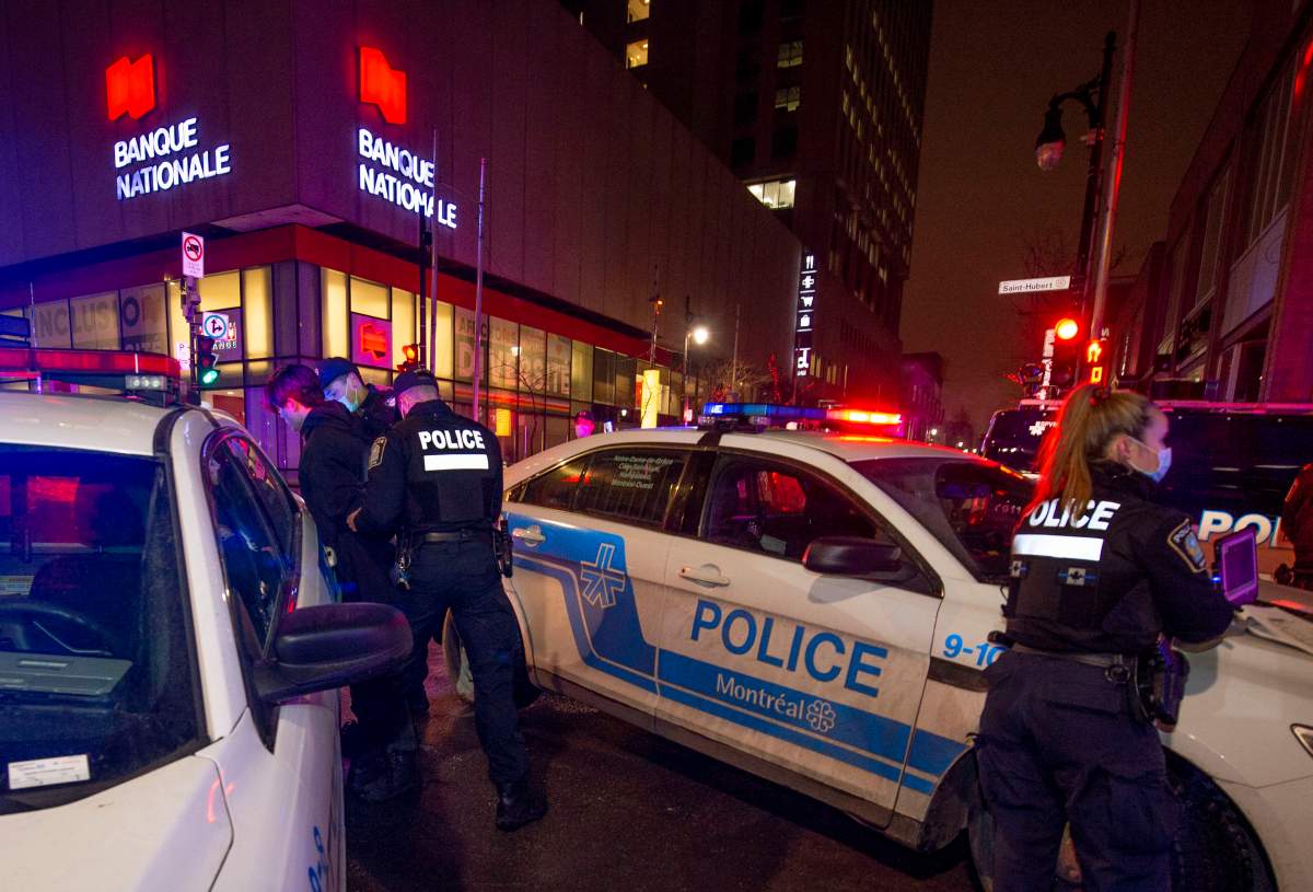 Police detain a man who ran from them at the start of a curfew in Quebec in Montreal on Friday, December 31, 2021, The 10pm to 5am curfew is intended to help stem the rise of infections due to COVID-19. 