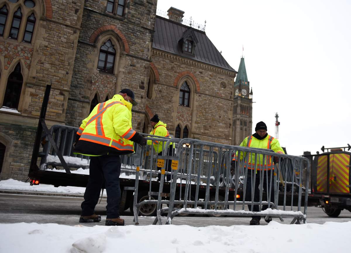 Public Works staff prepare fencing in front of Parliament Hill’s West Block in Ottawa, on Thursday, Jan. 27, 2022, before a cross-country convoy protesting a federal vaccine mandate for truckers is expected on Saturday. THE CANADIAN PRESS/Justin Tang