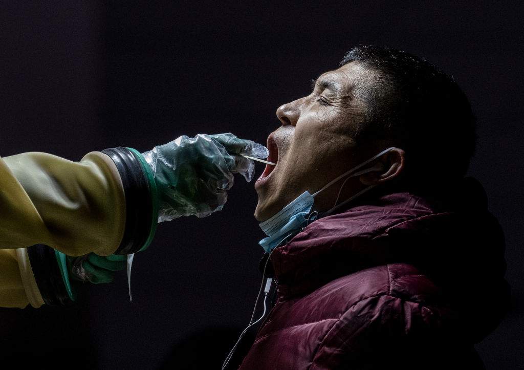 A man is given a nucleic acid test for COVID-19 by a health worker at a private testing site on January 13, 2022 in Beijing, China. (Kevin Frayer / Getty Images)