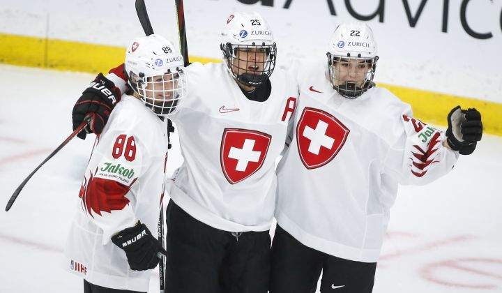 Switzerland’s Alina Muller, centre, celebrates her goal with teammates Sinja Leemann, right, and Phoebe Staenz during first period IIHF Women’s World Championship hockey action against Russia in Calgary, Saturday, Aug. 21, 2021.