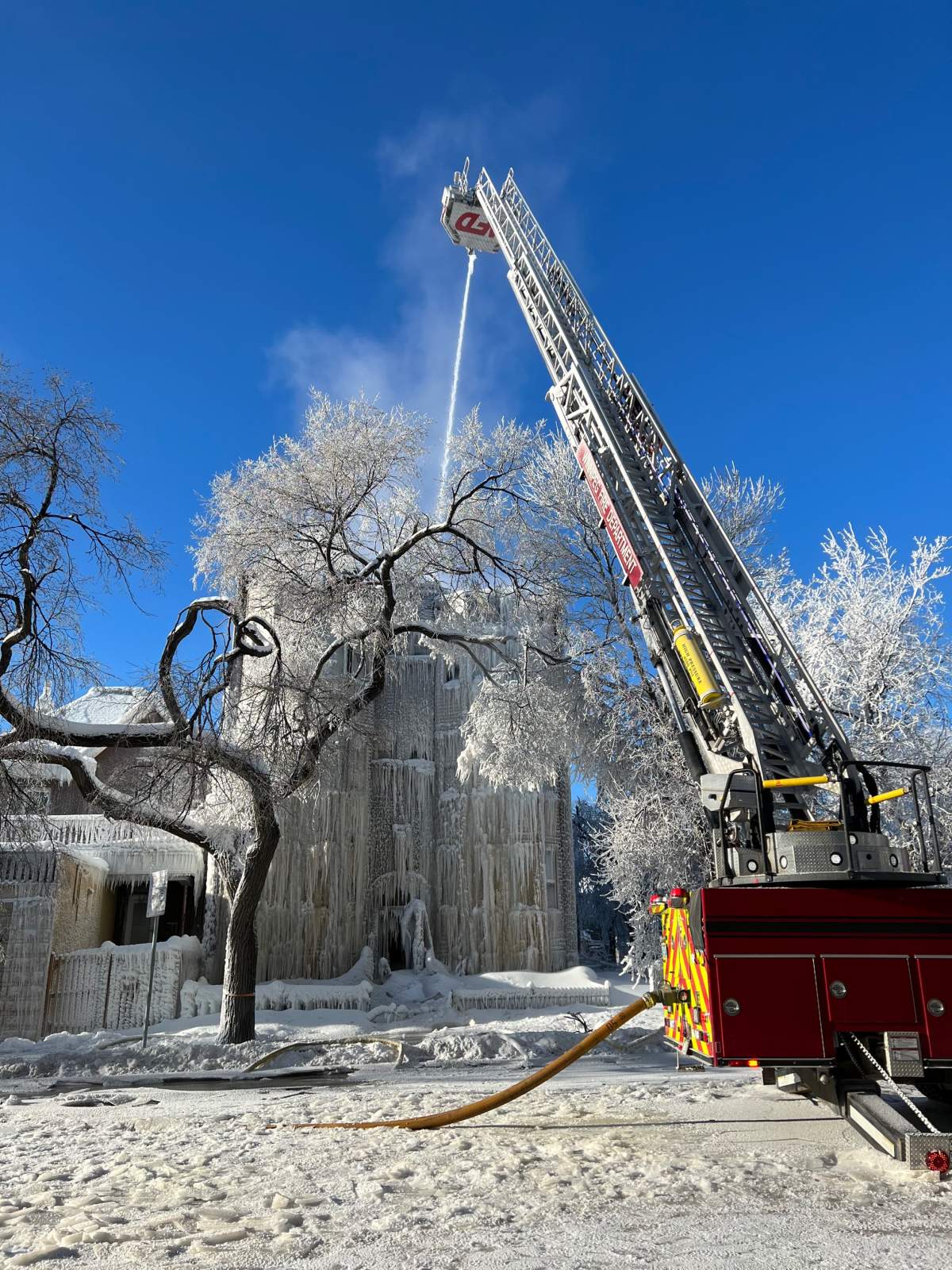 Fire fighters use an aerial hose to fight a fire at an apartment building on Sherbrook St. amid extreme cold and icy conditions Saturday afternoon.