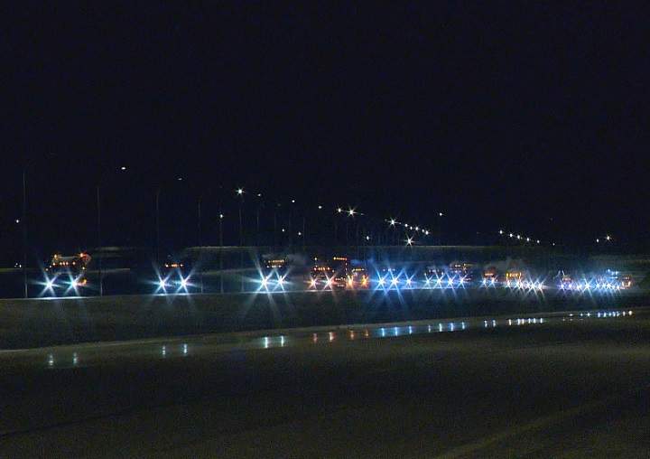 A long line of truck headlights shimmer in the night as they roll down the Regina Bypass on Monday.