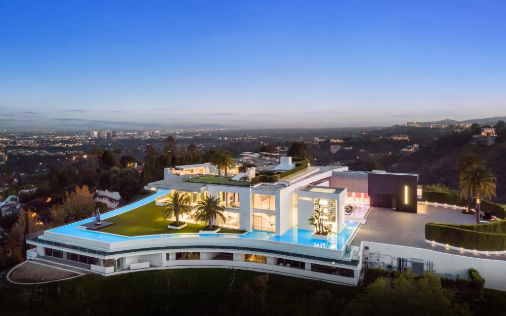 An aerial view of "The One" shows a massive mansion with a large moat surrounding it.