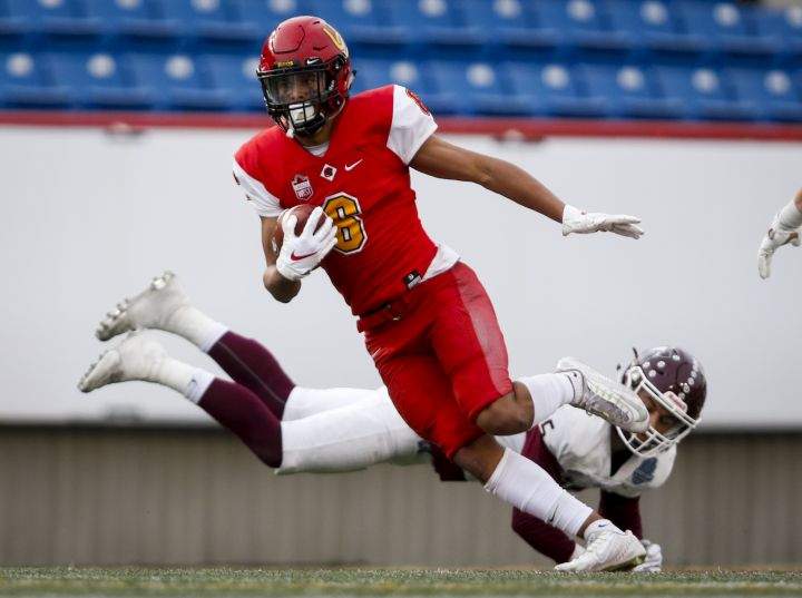 McMaster Marauders’ Levi Pau, right, looks on as University of Calgary Dinos’ Tyson Philpot runs the ball past him during second half U Sports Mitchell Bowl football action in Calgary, Saturday, Nov. 16, 2019.
